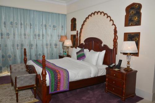 a bedroom with a large bed with a large mirror at Indana Palace Jaipur in Jaipur