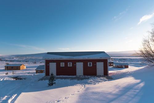a small building in the snow with footprints in the snow at Guesthouse Brekka in Brekka