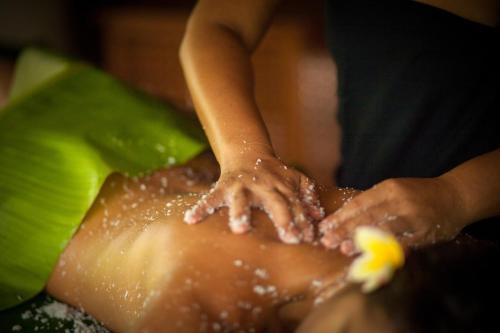 a child with hands on the back of a person in water at Sofitel Kia Ora Moorea Beach Resort in Maharepa