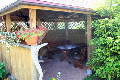 a wooden pergola with a table and a bench at Apartamenty Fala in Rowy