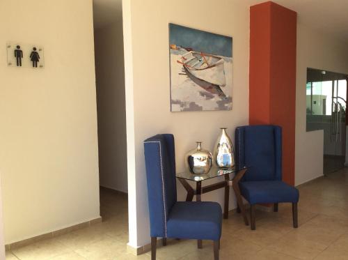 a dining room with blue chairs and a table at Villa Perfecta Zona Diamante in Acapulco