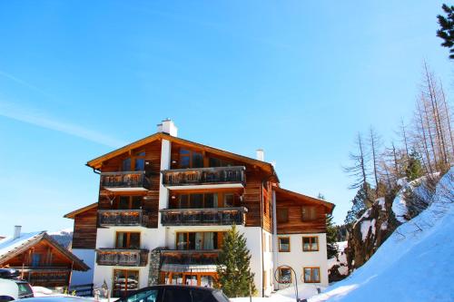 un gran edificio de apartamentos con nieve delante en Juniorsuite, en Turracher Höhe