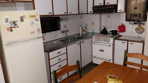 a kitchen with a white refrigerator and a table at Mendoza 398 in Rosario