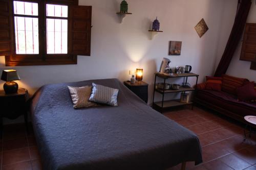 アルカウシンにあるBoutique Bed & Breakfast Casa Utopiaのベッドルーム(ベッド1台、ソファ付)