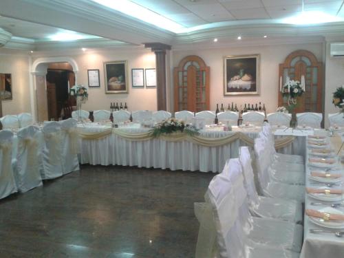 a banquet hall with white tables and white chairs at Business Club Selenča in Bač