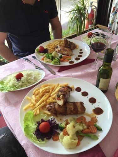 two plates of food on a table with plates of food at Business Club Selenča in Bač