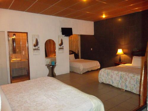 a hotel room with two beds and a television at Managua Hills in Managua