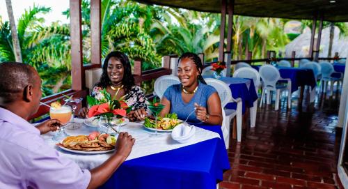 a group of people sitting at a table eating food at Hotel Maribu Caribe in Puerto Limón