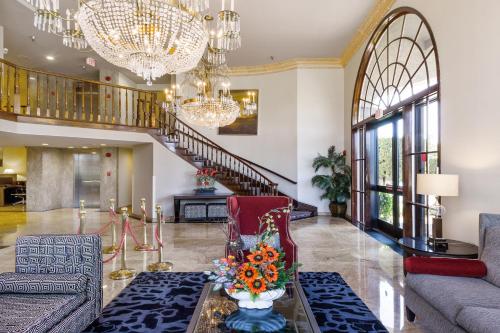 a living room with a couch and a table with flowers at Best Western Plus Newport Mesa Inn in Costa Mesa