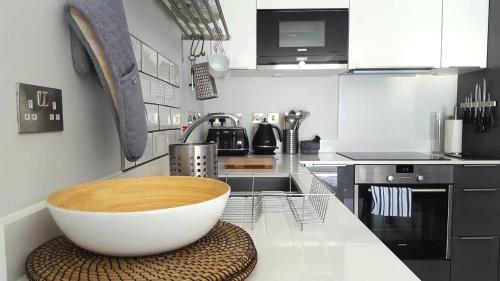 a kitchen with a large white bowl on a counter at Great Northern Road Apartment in Cambridge