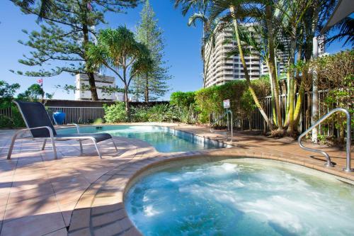 a swimming pool with a chair and a building at Wharf Boutique Apartments in Gold Coast
