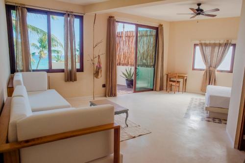 a living room with a white couch and windows at Maria Del Mar Tulum - Adults Only in Tulum