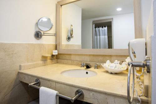 a white sink sitting under a mirror in a bathroom at Hotel Casablanca in San Andrés