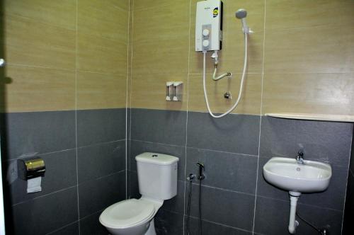 a bathroom with a toilet and a sink at Aloha Hotel in Lumut