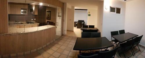 una habitación con mesas y sillas y una cocina en Hotel Villa Blanca, en Popayán