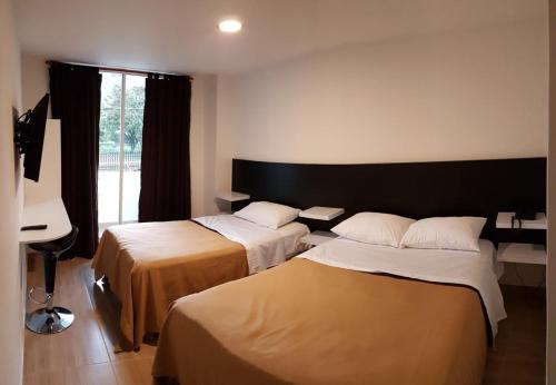 a hotel room with two beds and a piano at Hotel Villa Blanca in Popayan