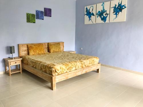 a bedroom with a bed and a side table at Koming Guest House in Canggu