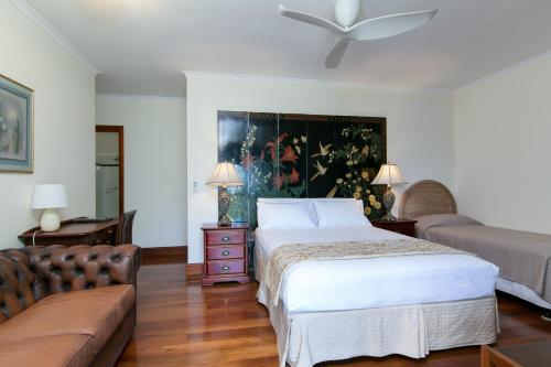 um quarto com uma cama e um sofá em Daintree Manor B&B em Daintree