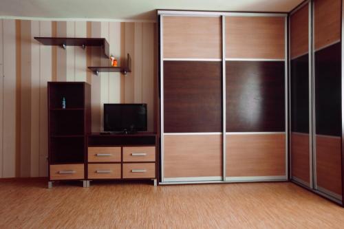 a room with a large closet with a tv and a television at Большая Подгорная 57 in Tomsk