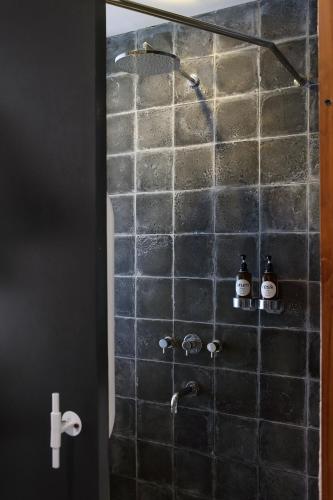 a shower in a bathroom with two bottles in it at YATS Colony in Yogyakarta