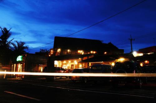 a street with cars parked in front of a building at night at Griya Gribig Guest House Mitra RedDoorz in Malang