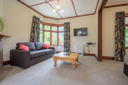a living room with a couch and a coffee table at Willowbrook Country Apartments in Arrowtown
