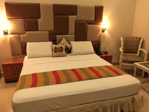 a bedroom with a large bed with a large headboard at Star Guest House in Karachi