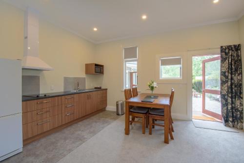 a kitchen with a wooden table and a dining room at Willowbrook Country Apartments in Arrowtown