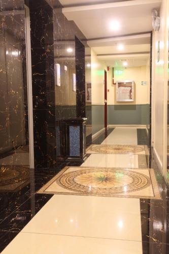 a hallway with a tile floor in a building at Hotel 99 Monumento in Manila