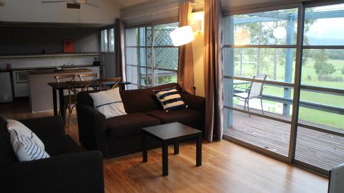 a living room with a couch and a table and a kitchen at Vineyard Hill in Lovedale