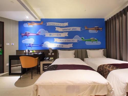 a room with two beds and a blue wall with signs at Stay Hotel - Taichung Zhongqing in Taichung
