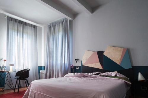 a bedroom with a bed and a desk and window at Locanda Ca' Matilde in Quattro Castella