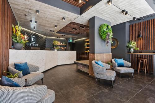 a lobby with chairs and a counter and a bar at District South Yarra in Melbourne