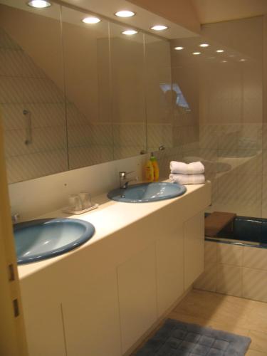 a bathroom with two sinks and a large mirror at B&Logies De Duinroos Koksijde in Koksijde