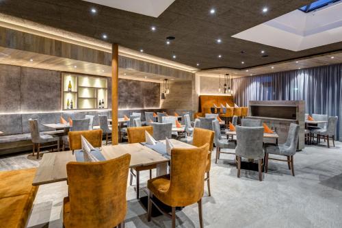 a restaurant with tables and chairs and a piano at Hotel Klostersepp in Chiusa