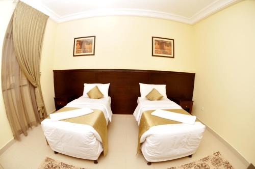 Una cama o camas en una habitación de Narjes Al Hadeqa Hotel