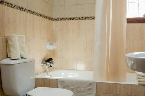 プラヤ・ミジョーンにあるApartamentos Es Carnatge - Formentera Vacacionesのバスルーム(トイレ、洗面台、バスタブ付)