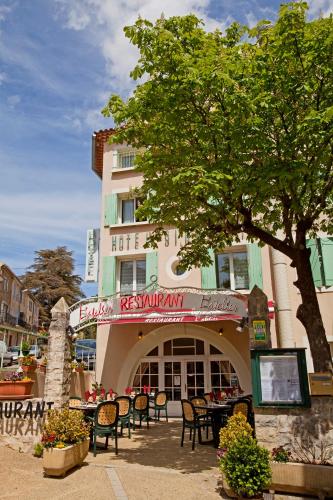 a restaurant with tables and chairs in front of a building at Le Signoret in Sault-de-Vaucluse