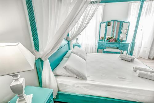 - une chambre bleue et blanche avec un lit et un miroir dans l'établissement Belone Suite, à Corfou