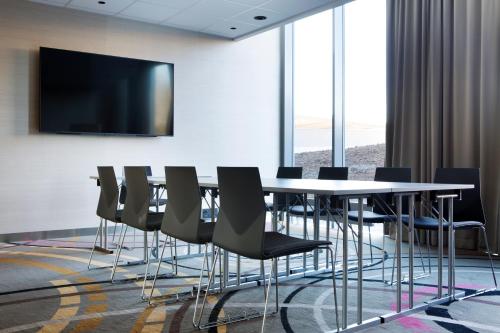 a conference room with a table and chairs and a flat screen tv at Comfort Hotel Bergen Airport in Bergen