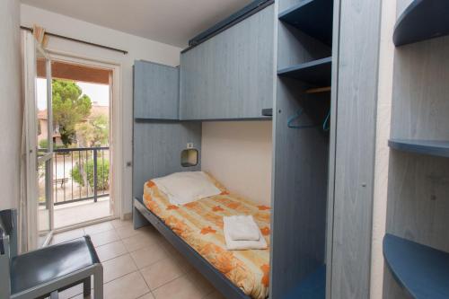 a small bedroom with a bed and a window at Village Vacances Passion La Grande Bastide in Le Lavandou