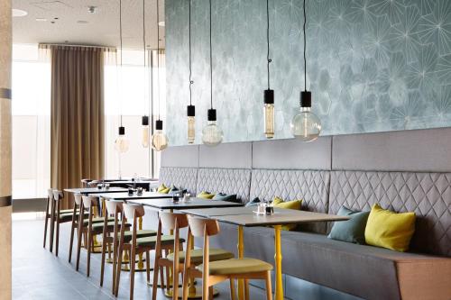 a row of tables and chairs in a restaurant at Comfort Hotel Bergen Airport in Bergen