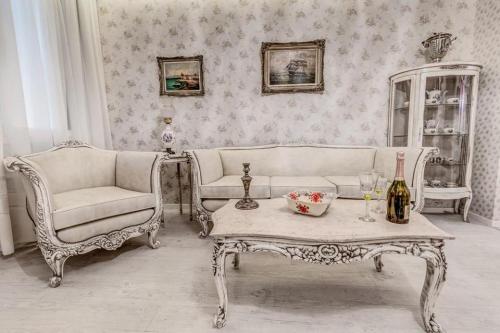 ein Wohnzimmer mit einem Sofa, einem Tisch und Stühlen in der Unterkunft Bebeto Suite in Korfu-Stadt