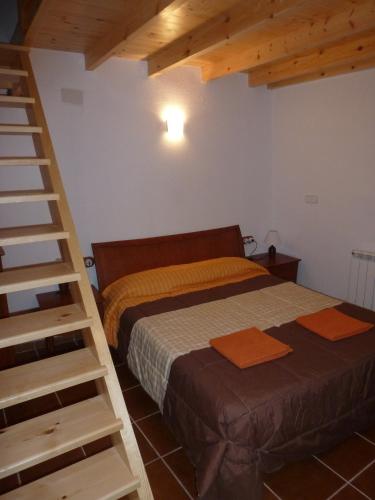 a bedroom with a bed and a wooden ladder at Cal Vidal in Mura