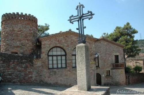 a cross in front of a brick building at Cal Vidal in Mura