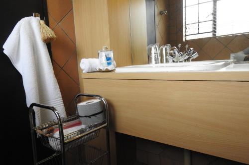 een badkamer met een wastafel en een handdoek bij Willow Place Guest House in Midrand