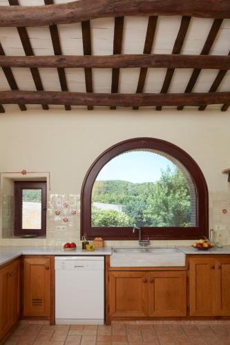 a kitchen with a sink and an arch window at La Requisa in Pontós