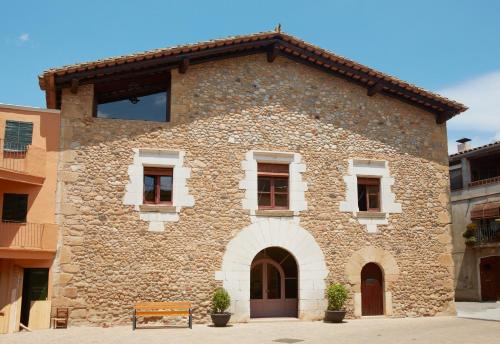 a stone building with a bench in front of it at La Requisa in Pontós