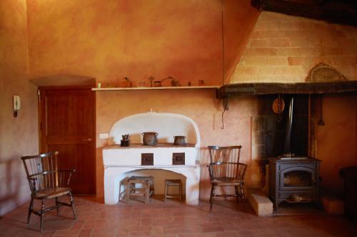 a kitchen with a stove with chairs and an oven at La Requisa in Pontós