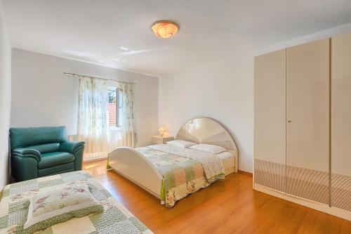 sypialnia z łóżkiem, krzesłem i lustrem w obiekcie Apartments Kamenjak w mieście Premantura